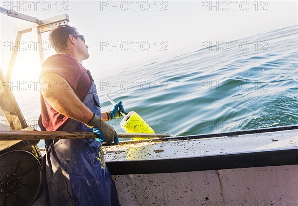 Fisherman throwing lobster buoy