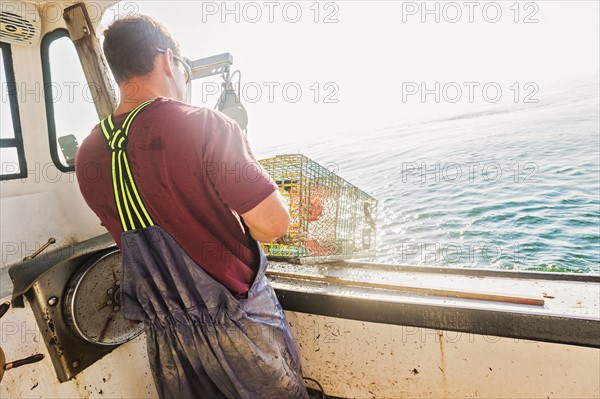 Fisherman throwing lobster trap