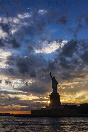 Silhouette of Statue of Liberty at sunset