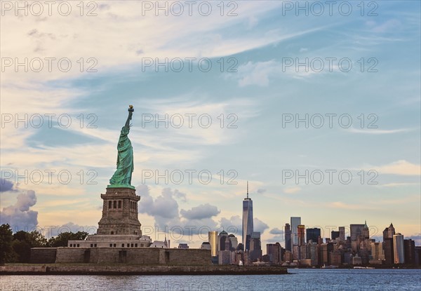 Statue of Liberty and financial district at dusk