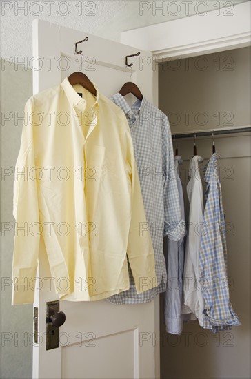 Button down shirts hanging on cloth hangers