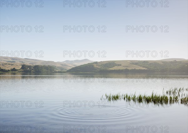 Lake by hills and clear sky