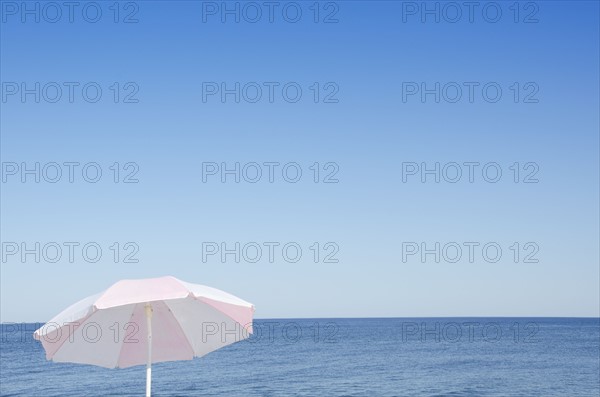 Sunshade against blue seascape
