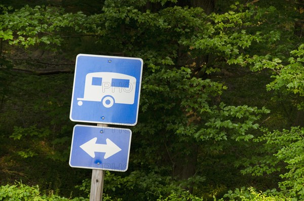 Blue road sign with forest in background