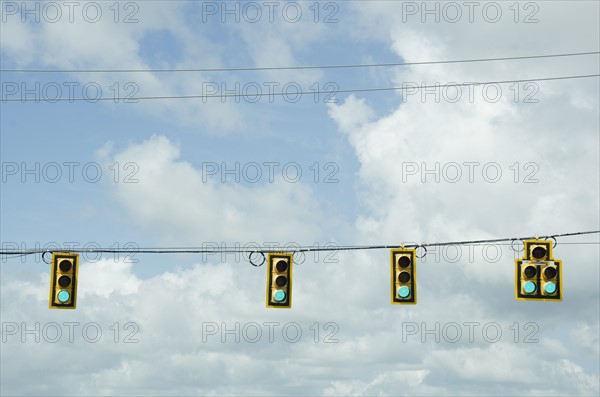 Road signals on cable against cloudy sky