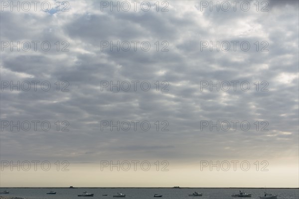 Cloudscape above sea with boats