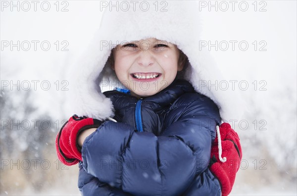 Portrait of boy (6-7) in fur hat and gloves