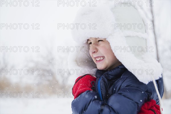 Portrait of boy (6-7) in fur hat and gloves