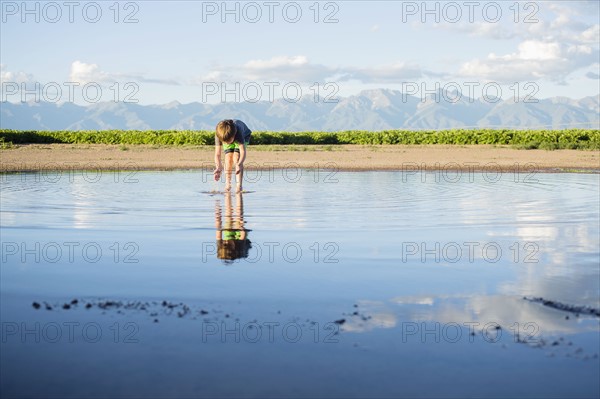Boy (6-7) wading in water