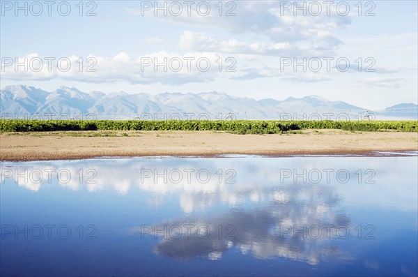Clouds reflecting in lake with mountains in background