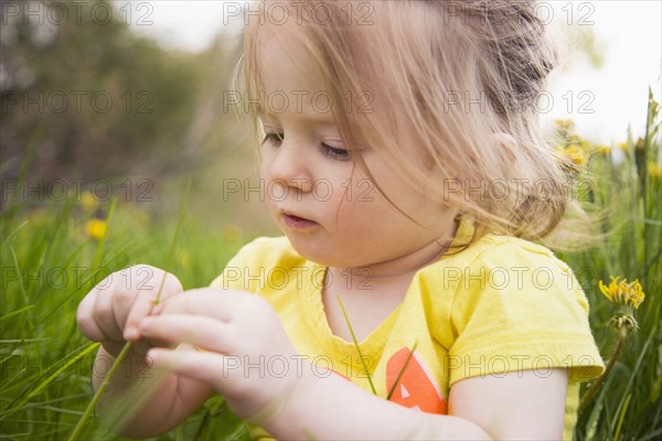 Portrait of girl (2-3) playing in grass