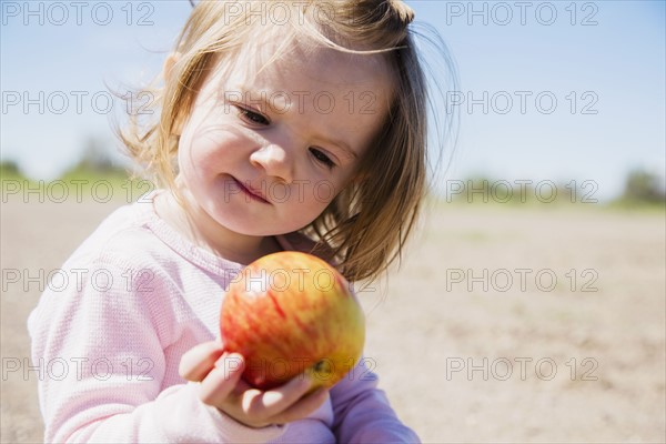 Portrait of girl (2-3) holding apple