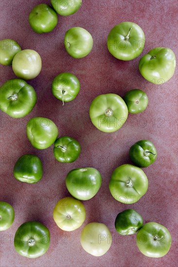 Green tomatillos on red background