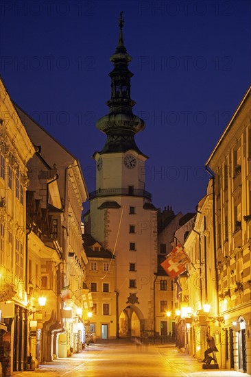 Illuminated alley and tower at night