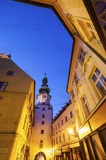 Illuminated townhouses and tower at dusk