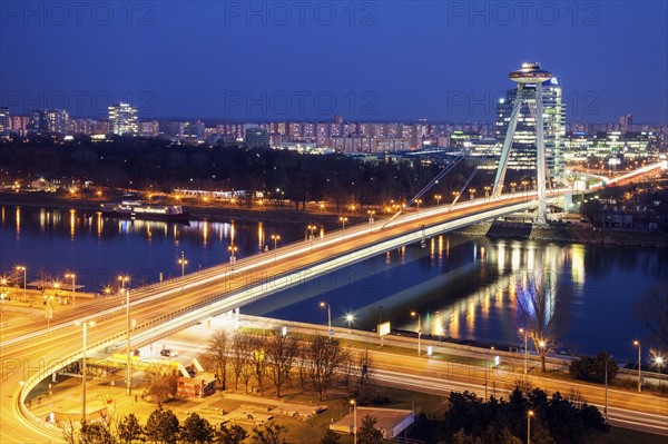 Illuminated bridge over river at night