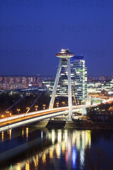 Illuminated bridge over river at night