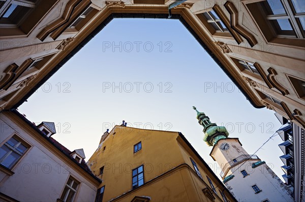 Townhouses and tower against sky