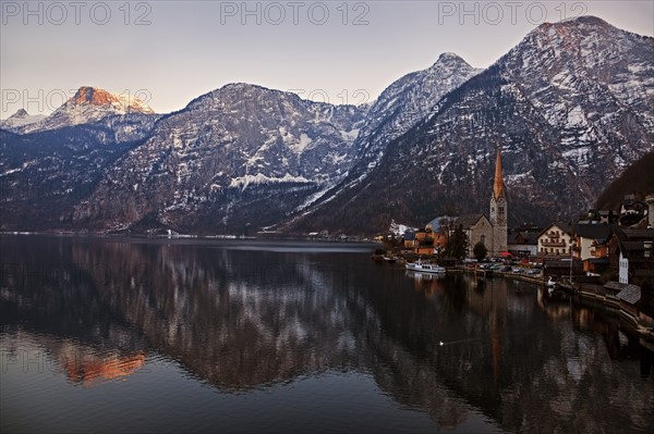 Town and mountains reflecting in lake