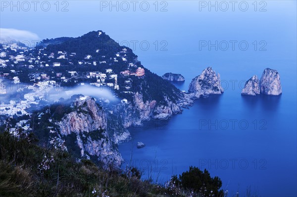 Coastal town and Faraglioni at sunset