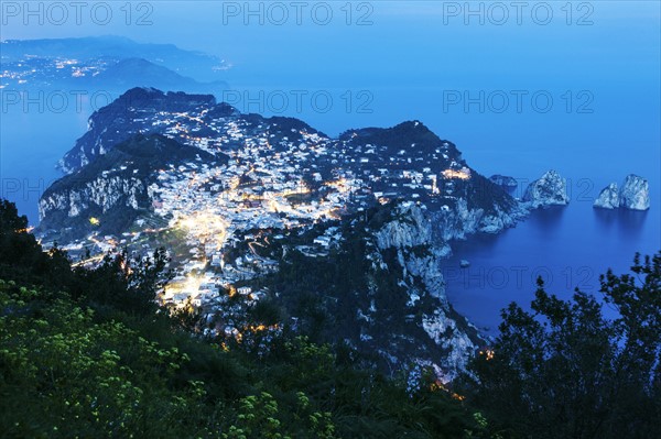 Illuminated cityscape on island at dusk