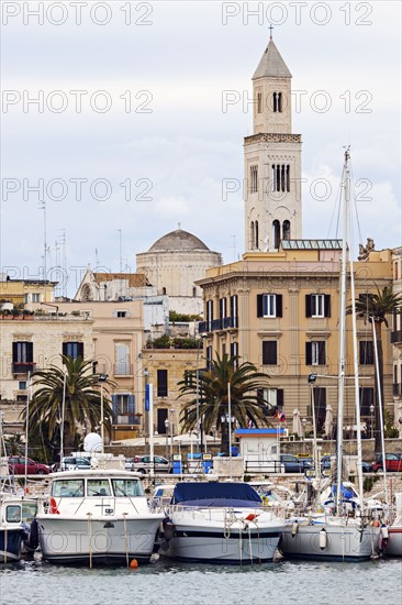 Boats in marina with city buildings in background