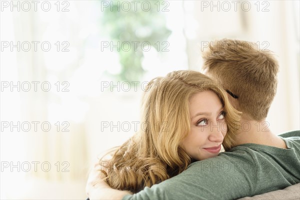 Young woman looking over boyfriend's shoulder.