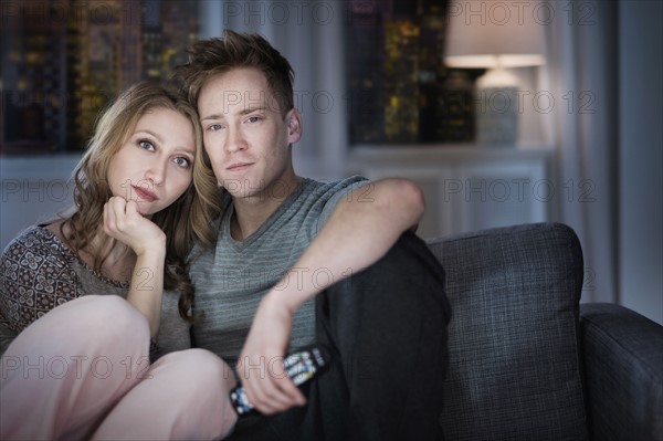 Young couple watching TV at night.