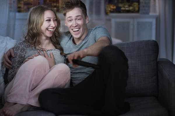 Young couple watching TV at night.