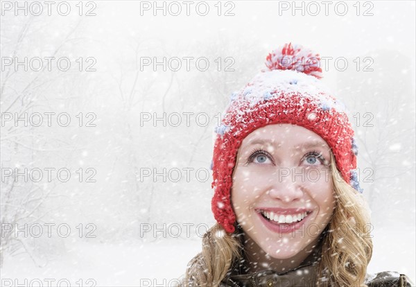 Woman in red knit hat looking up.