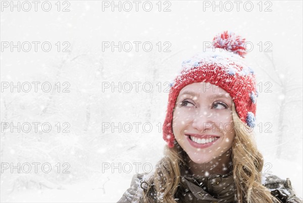 Woman in red knit hat looking away.