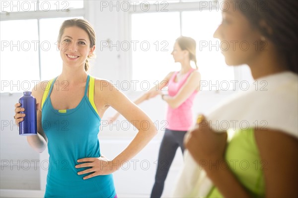 Portrait of woman holding sport drink at gym.