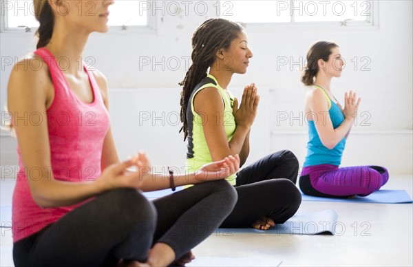 Women in lotus position meditating.