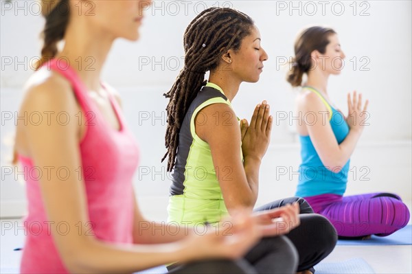 Women in lotus position meditating.