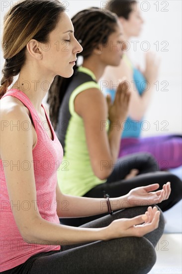 Women in lotus position meditating.