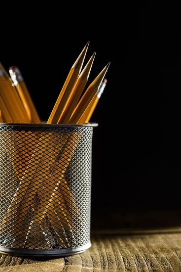 Sharp pencils in metal container.