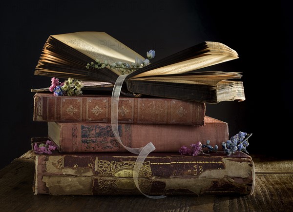 Stack of old books on table.