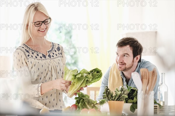 Man and woman in kitchen, smiling.
