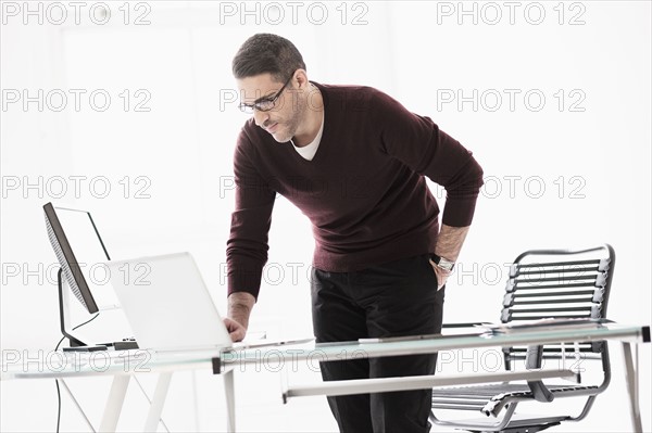 Man using laptop in office.