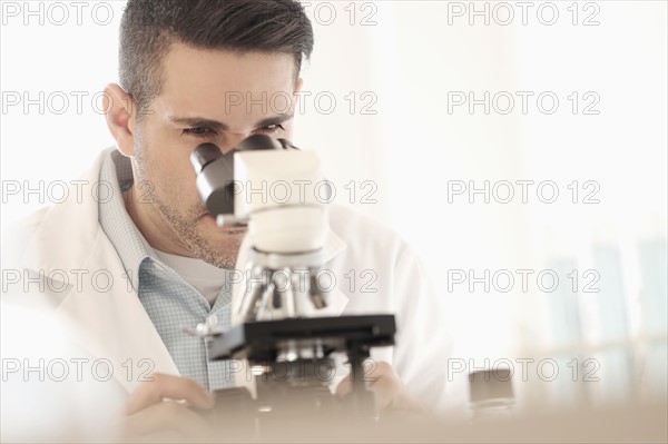 Man looking through microscope.