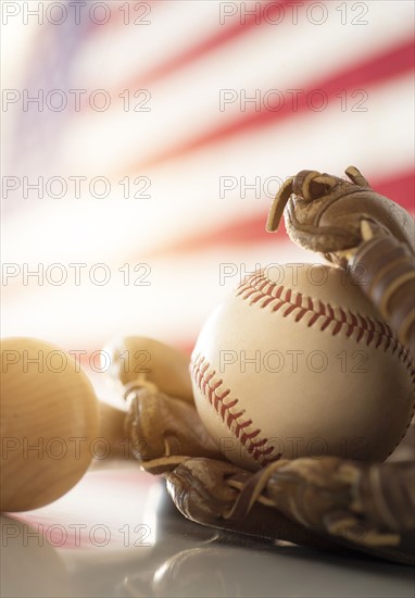 Close-up of baseball glove, ball and bat.