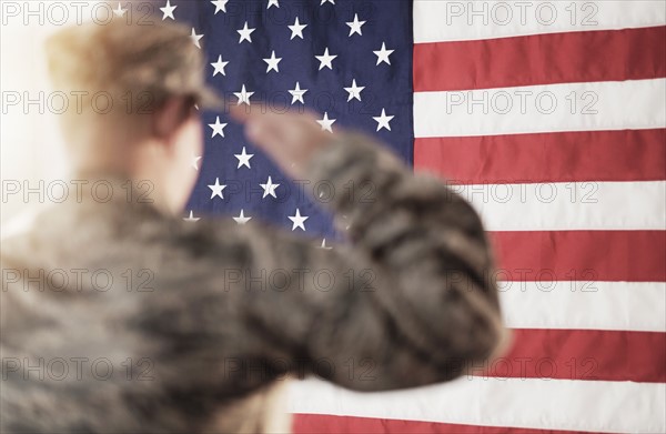 Soldier saluting American flag.