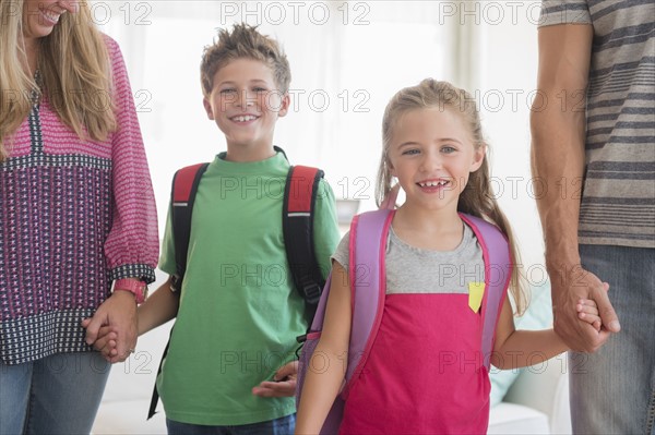 Two children (6-7, 8-9) holding parents' hands