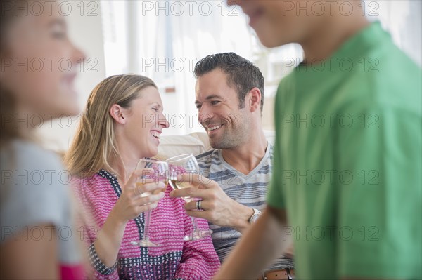 Man and woman sitting on sofa and drinking wine