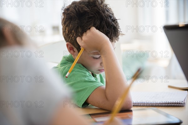 Boy (8-9) concentrating on homework