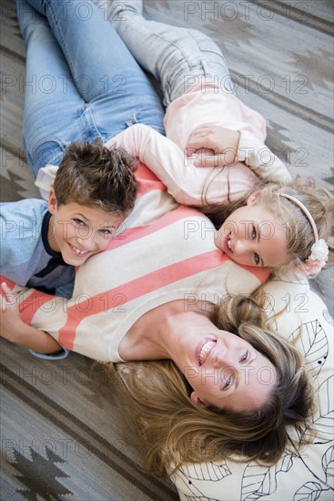 Mother lying down with son (8-9) and daughter (6-7)