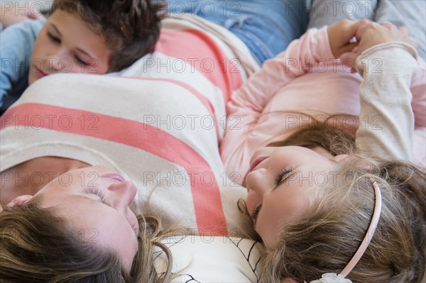 Mother lying down with son (8-9) and daughter (6-7)