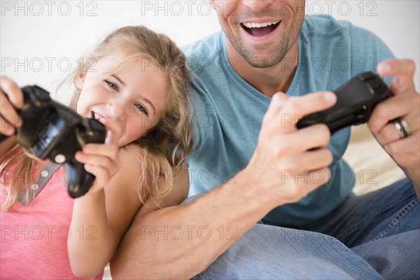 Father and daughter (7-8) playing video game