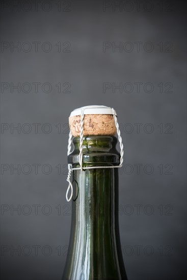 Studio shot of champagne bottle with cap on black background