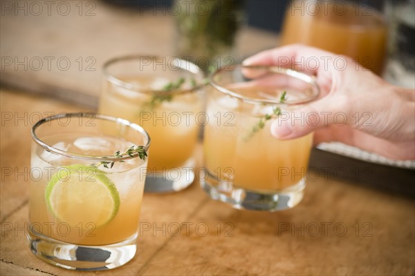 Woman's hand holding drinking glass with cocktail